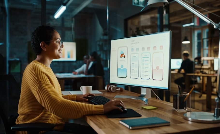 Young Latina Designer Working on a Desktop Computer in Creative Office. Beautiful Diverse Multiethnic Female is Developing a New App Design and User Interface in a Digital Graphics Editing Software.